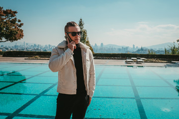 person talks on phone near pool
