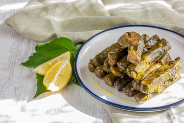 Traditional turkish meal - Yaprak sarma. Grape leaves stuffed withrice and spices. Served with olive oil and fresh lemon