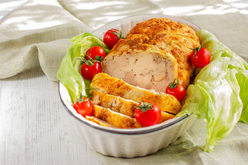 Homemade chicken ham. Oven baked chicken roll. Cold meat served with fresh cheery tomatoes and lettuce