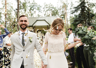 wedding confetti,newlyweds are greeted with festive confetti,joyful bride and groom go on a wedding...