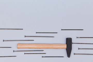 Hammer instrument. Bunch of tacks isolated on blue background. Handyman tool. Renovation concept. Copy space for text