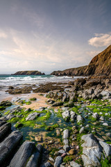 On the beach of Marloes Sands beach, with sand, rocks and rock pools and the sea in the distance, South Wales