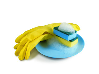 Two sponges with foam on blue plate next to yellow rubber protective gloves isolated on white background. Dish washing.