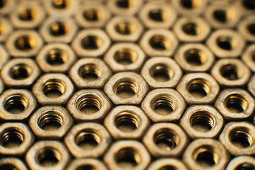 Close-up, macro. Old soviet brass nuts. Texture, background of brass nuts laid out in the form of...