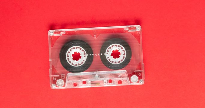 4k stop motion retro music compact cassette reeling tape on yellow background.