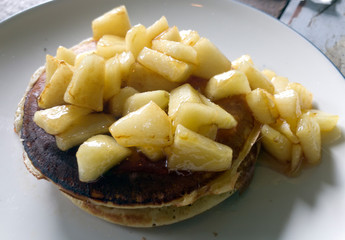 Two pancakes on a plate and fruit