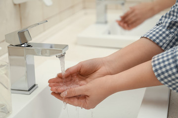 Fototapeta na wymiar Woman washing hands with antiseptic soap in public restroom, closeup. Virus prevention