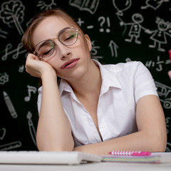 Fototapeta premium Young female student sleeping in a classroom