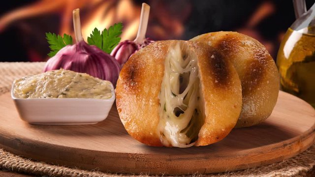 Baked Garlic bread and cheese on the table with fire background. Brazilian Barbecue concept. Garlic cream