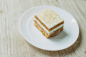 Honey cake in a white saucer on the table