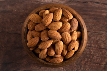 Bowl Full of Raw Natural Almonds on a Dark Wood Table