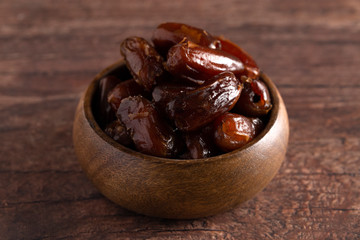 Bowl of Pitted Dates on a Dark Wood Table