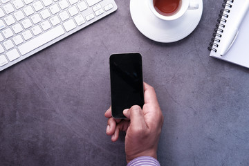 young man hand holding smart phone with empty screen 