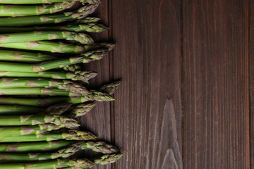 Fresh raw asparagus on wooden table, flat lay. Space for text