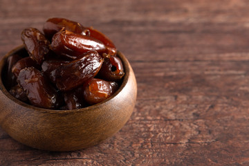 Bowl of Pitted Dates on a Dark Wood Table