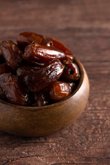 Bowl of Pitted Dates on a Dark Wood Table
