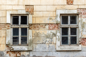 Fototapeta na wymiar Two vintage windows in a white wooden frame on a grunge damaged wall.