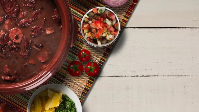 Slide shot Brazilian feijoada on the table with smoke. Top View