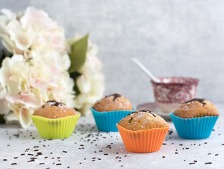 handmade muffins with chocolate shavings and a cup of coffee. Colorful wrappers.
