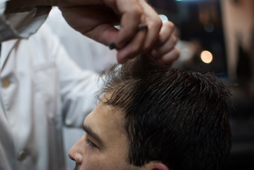 Obraz na płótnie Canvas Handsome man taking haircut at the barbershop 