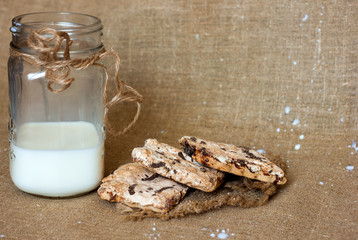 Milk in a glass jar and cookies on a natural homespun napkin, ecology, health and proper nutrition