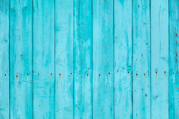 Wooden boards on an old blue fence as an abstract background.
