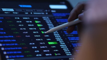 trader use pen and laptop working with forex and cryptocurrency data and bar chart, invester concept. - Powered by Adobe