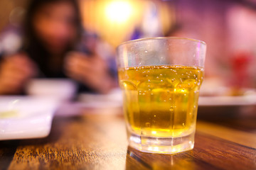 A glass glass with a drink stands on a table