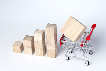 Graphs chart wooden cube block and trolley cart on a white background. Shopping, sale, finance, and business concept. 