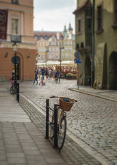 rower zaparkowany na brukowanej ulicy, stare miasto w tle