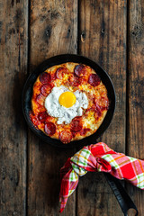 Sourdough breakfast skillet pizza with fried egg, pepperoni and mozzarella cheese