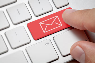 Online Communication concept:Macro male hand pressing computer key with e-mail illustration....