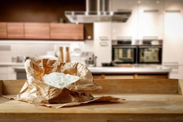 Flour on the table in a beautiful new kitchen with free space for an advertising product