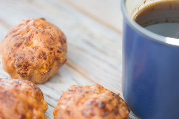 Cup of black coffee and muffin on white wooden desk. Selective focus.