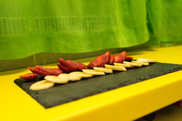 Slices of strawberries and bananas on a slate board / Rodajas de fresas y plátanos sobre una tabla de pizarra