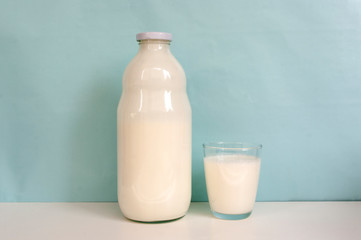 Glass and bottle of milk, on blue background. Milk product. Nutrition food.