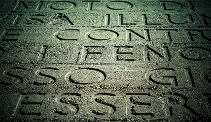 Letters on a rough concrete surface.