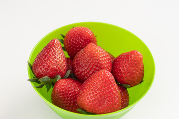 Juicy red strawberries in a green bowl