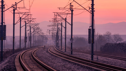 Fototapeta na wymiar Railway into the light of a beautiful sunrise