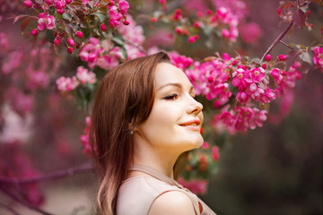 portrait of a beautiful young woman with make-up near a tree with flowers