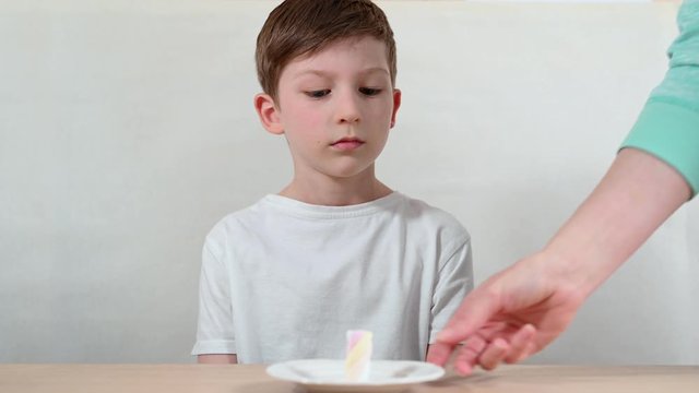 marshmallow experiment leader explains test rules and schoolboy fights with desire languishing and putting head on arms closeup