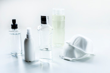 bottle of perfume and protective mask on white background