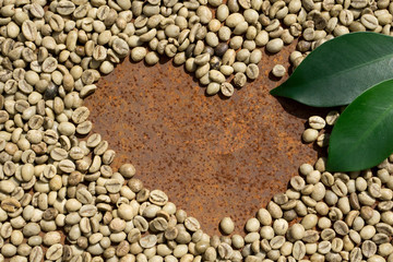  Flat lay  of   green coffee beans in the shape of heart , green leaf on rustic iron
