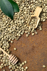  Flat lay  of   green coffee beans, green leaf, wooden spoon on rustic iron