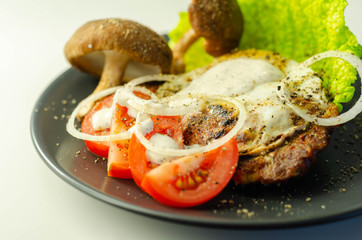 The fried portion of gammon served with egg, fresh lettuce, tomato, onion and funguses
