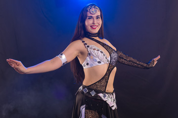 Portrait of a woman in oriental costume performing belly dance. Tribal fusion dance concept.