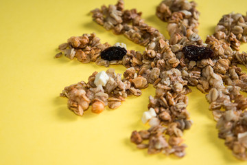 muesli fried in the sun dried fruits raisins on a yellow background place for text
