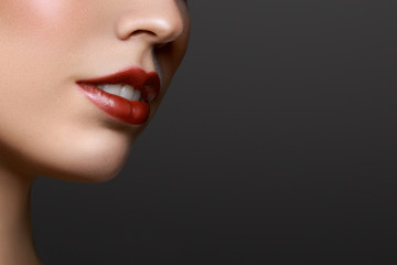 Naklejka premium Close-up portrait of beautiful young woman lips with bright red lipstick