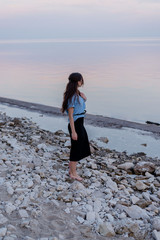 Young beautiful woman walking along the coast