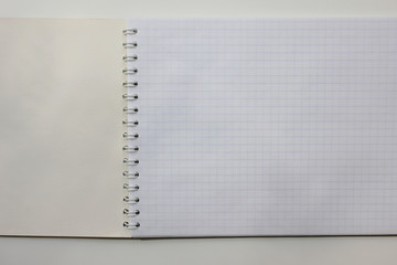 Notebook white blank open page close up top view. New office product, spiral note book design with empty pages. Plain squared notepad with no text, conceptual background